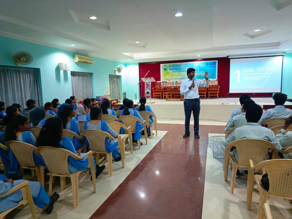 Photo of PCS Board member, Aravindhan Anbazhagan, speaking to students at last month’s event at IEEE Student Xavier College of Engineering. We see Anbazhagan in the front center of a room of approximately 80 college students.